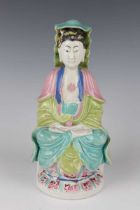 A Chinese famille rose enamelled porcelain figure of Guanyin, Qianlong period, modelled seated on