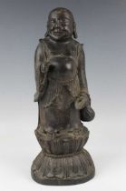 A Chinese bronze figure of Buddha, probably Ming dynasty, modelled standing wearing an open robe,