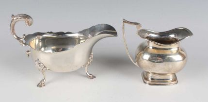 A George V silver sauceboat with foliate capped flying scroll handle, on scallop shell shouldered