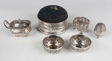 An Edwardian silver mustard of cushion form, embossed with foliate scrolls, on ball feet, Birmingham