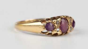 An 18ct gold, amethyst and diamond ring, mounted with three amethysts alternating with two pairs