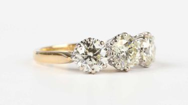 An 18ct gold and diamond three stone ring, claw set with circular cut diamonds, Birmingham 1998,