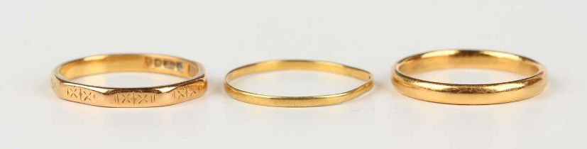 A 22ct gold wedding ring, London 1932, a 22ct gold faceted wedding ring with engraved decoration,