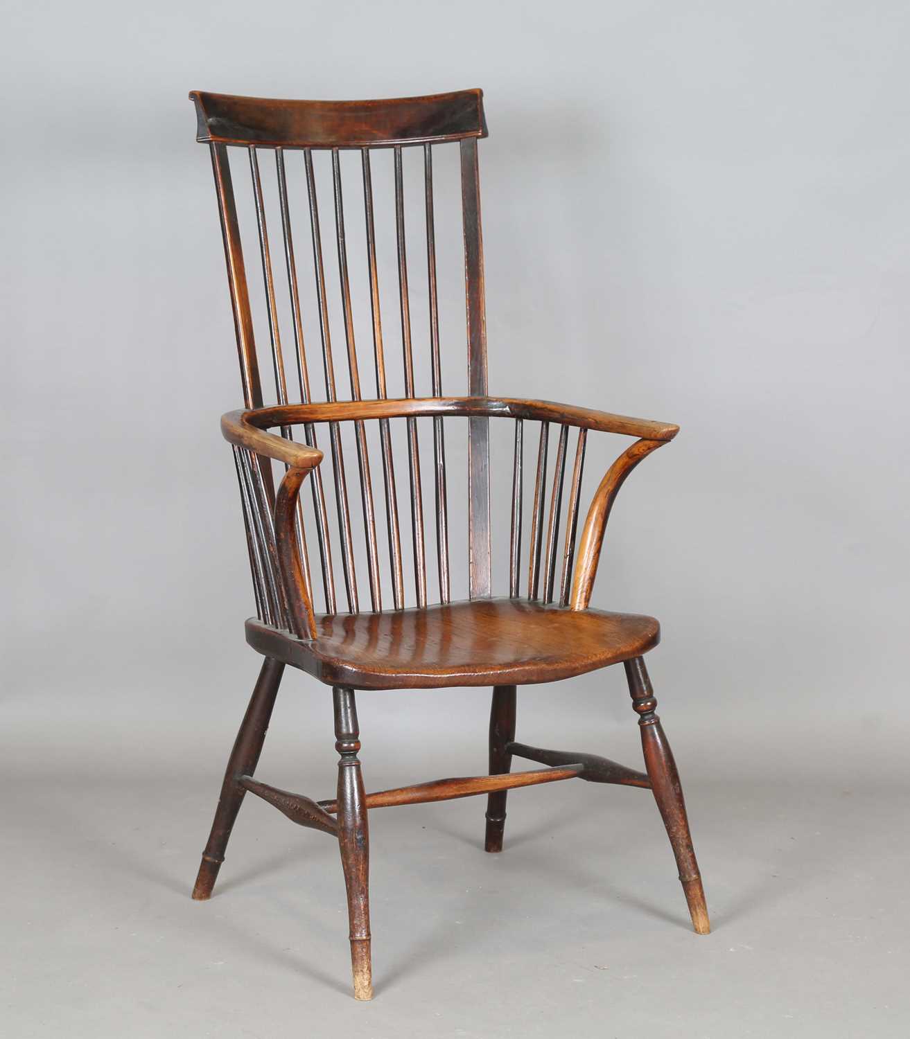 A mid-19th century provincial ash and elm bar and stick back Windsor armchair with a wide elm seat