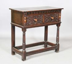 A mid-20th century Jacobean Revival oak side table, fitted with a pair of foliate carved drawers,