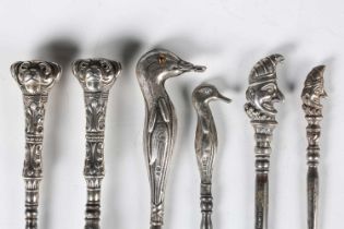 A group of five silver-handled novelty buttonhooks and a similar shoehorn, two with pug dog head