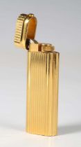 A Cartier Paris gilt metal curved rectangular gas lighter, detailed 'Cartier Paris 29071 V',