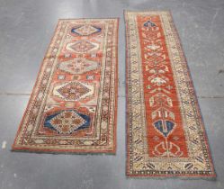 An Afghan 'Kazak' design runner, late 20th century, the red field with five hooked medallions,