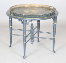 A 19th century tole painted tin circular tray-topped table, painted with a portrait of a lady and