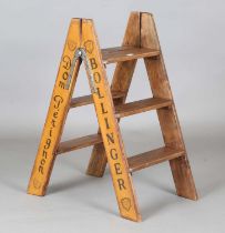 A modern stepladder, signwritten to the sides with champagne advertising, height 81cm, depth 43cm.