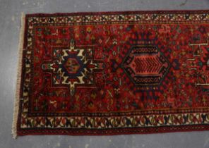 A Heriz runner, North-west Persia, mid/late 20th century, the red field with seven medallions,