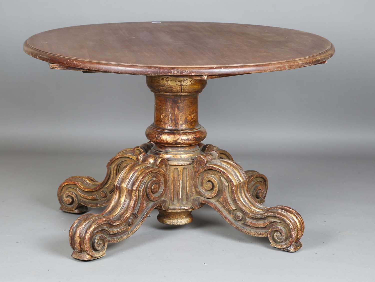 A 19th century giltwood table base with a later removable top, the base carved with scrolling legs