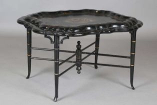 A Victorian papier-mâché tray-top table of serpentine outline, inlaid and painted with a titled view