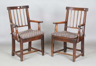 A harlequin set of six George III provincial oak comb back dining chairs with solid panel seats,