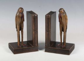 A pair of early 20th century Continental carved softwood and Bakelite mounted novelty bookends, each