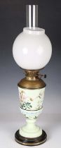 A late Victorian Aesthetic Movement pale green opaque glass oil lamp, enamelled with flowers and a