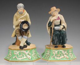 A rare pair of English porcelain blind beggar figures, mid-19th century, modelled as a seated man