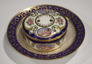 A Sèvres circular dish with integral fixed stand and pierced cover, circa 1773, painted with oval