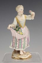 A Meissen figure of a girl, late 19th century, holding flowers in her apron and a small posy