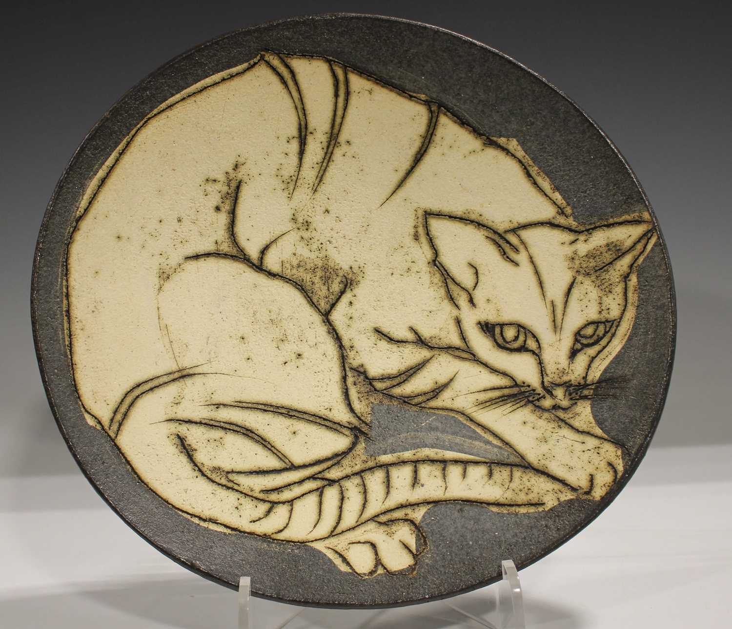 A studio pottery stoneware circular dish by Laurel Keeley, incised with a cat, incised mark to