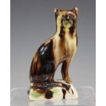 A Whieldon type glazed pottery model of a cat, circa 1800, modelled seated on a rectangular base,
