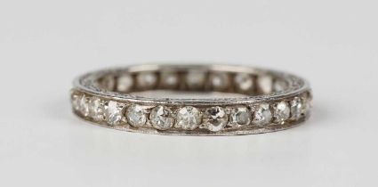 A diamond eternity ring, mounted with variously cut diamonds within scroll engraved sides, unmarked,