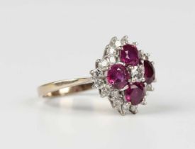 A gold, ruby and diamond cluster ring, claw set with principal circular cut diamond within a