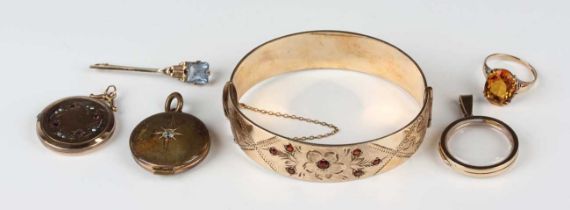 A gilt metal and garnet oval hinged bangle with floral decoration, on a snap clasp, inside width 6.