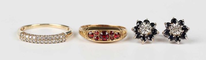 An 18ct gold and garnet ring, mounted with seven cushion cut garnets, Birmingham 1920, weight 2.