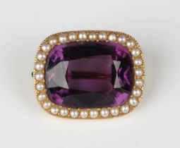 A gold, amethyst and seed pearl curved rectangular brooch, mounted with the large central mixed