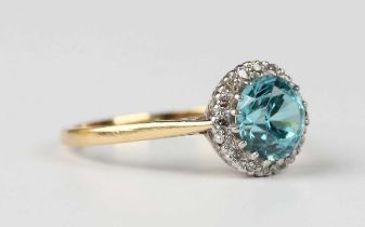 A gold and platinum, blue zircon and diamond cluster ring, claw set with the circular cut blue