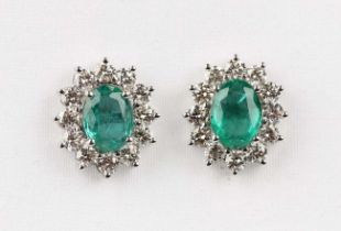A pair of white gold, treated emerald and diamond oval cluster earstuds, each claw set with the oval