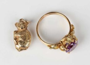 A gold ring mounted with a circular cut synthetic colour change corundum, the shoulders and sides