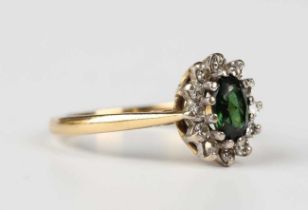 An 18ct gold, green tourmaline and diamond oval cluster ring, claw set with the oval cut green