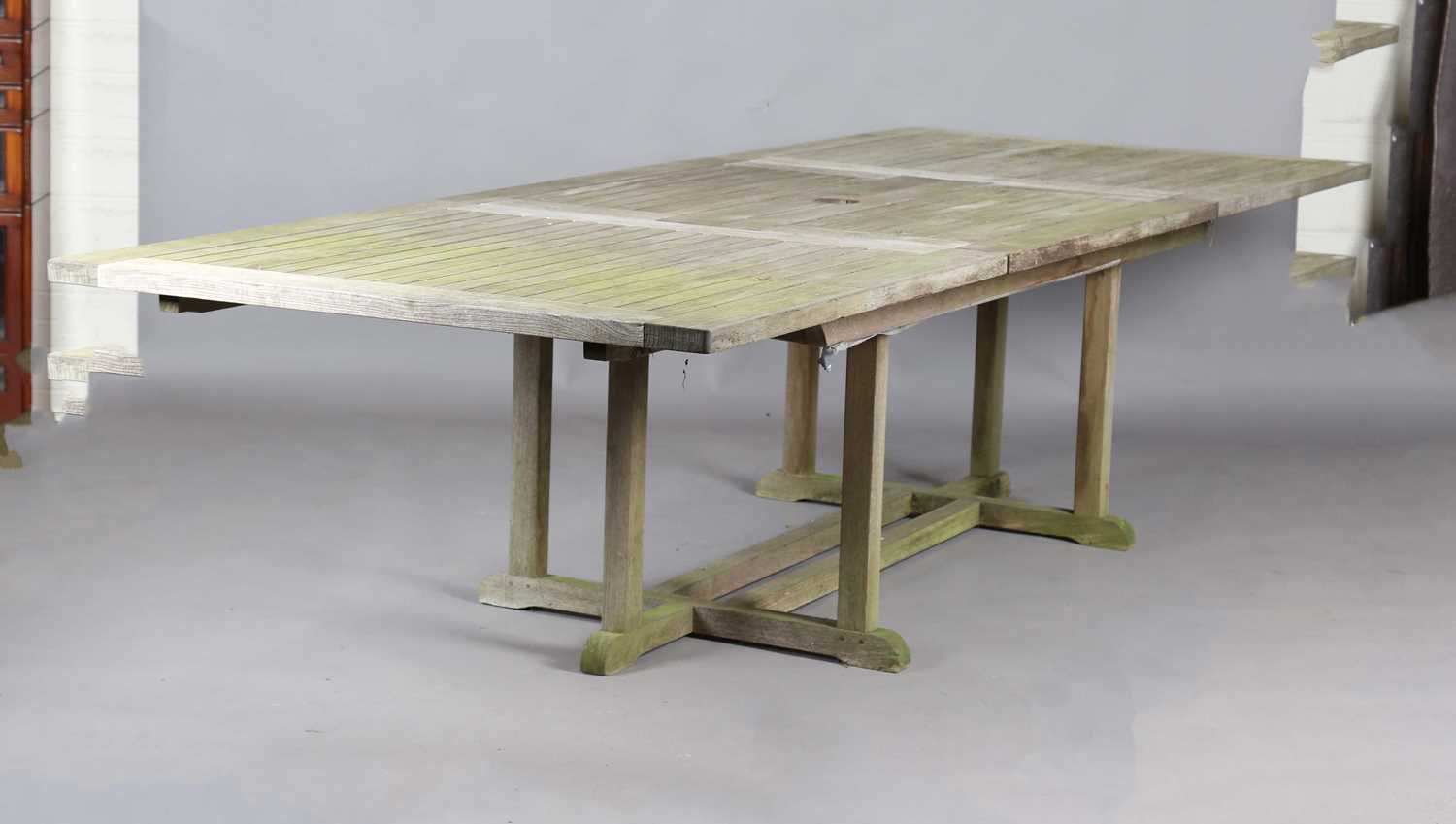 A late 20th century teak extending garden table by Gloster, height 70cm, extended length 310cm,