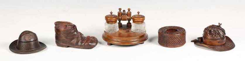 A group of five mainly late 19th century carved treen inkwells, two carved as hats, one in the