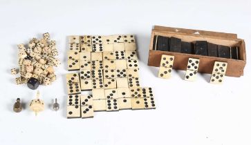 A group of 19th century bone and ebony dominoes, approximately fifty bone dice and three spinners.