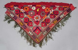 An Uzbekistan silk embroidered suzani, the triangular panel finely worked with scrolling