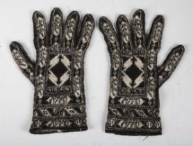 An unusual pair of Persian wool gloves, finely woven in black and white with panels of Islamic