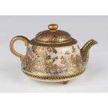 A Japanese Satsuma earthenware teapot and cover, Meiji period, painted and gilt with pheasants and