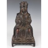 A Chinese Ming style brown patinated bronze figure of Buddha with traces of gilt, modelled seated