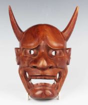 A Japanese carved wood noh mask of Hannya by Sukemasa, with finely carved and pierced facial details