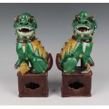 A pair of Chinese famille verte enamelled biscuit porcelain figures of Buddhistic lions, each green,