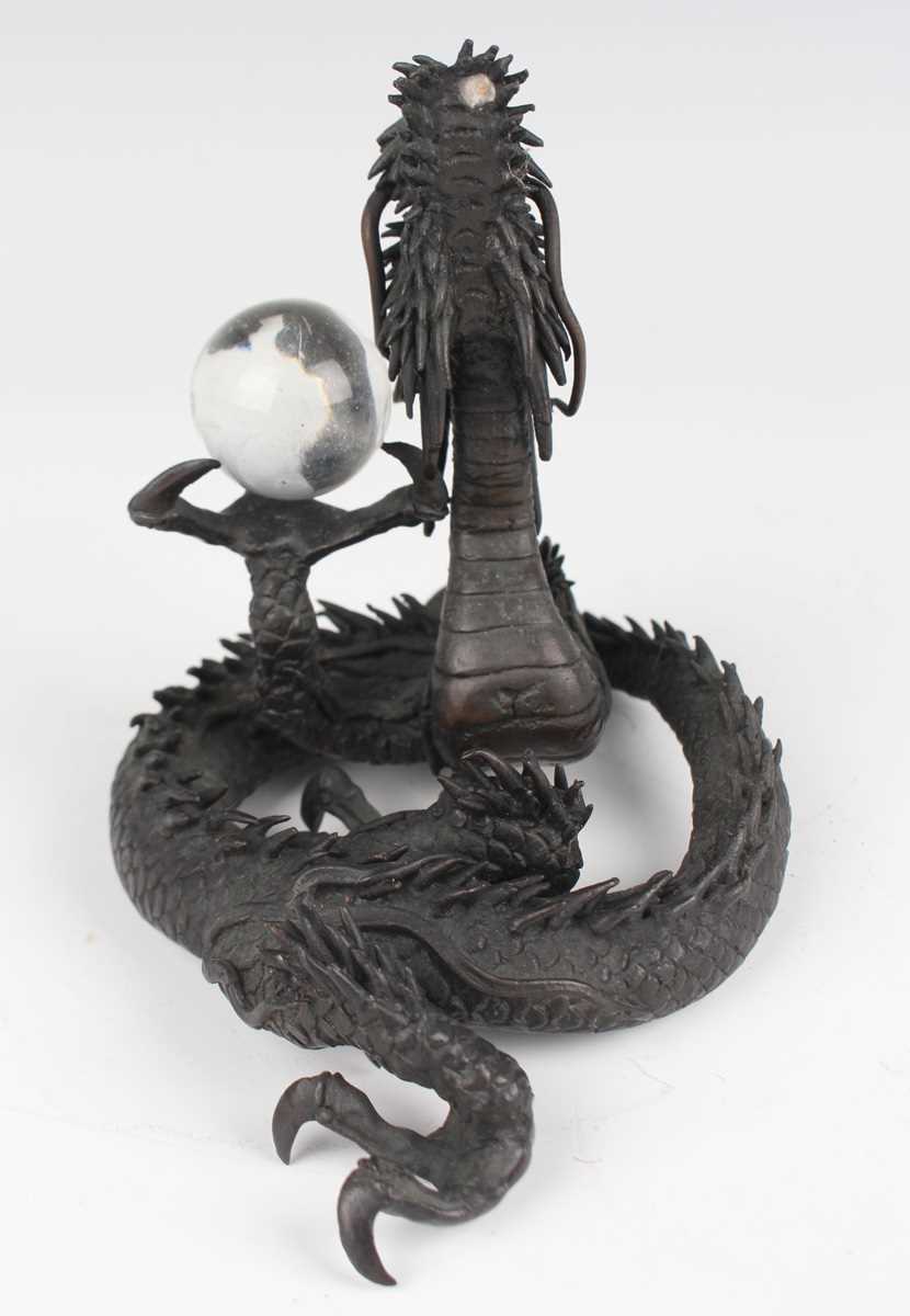 A Japanese cast bronze figure of a dragon, 20th century, modelled in a coiled pose holding a - Image 3 of 9