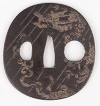 A Japanese cast iron oval tsuba, Edo period, with silver damascened dragon and vapour decoration,