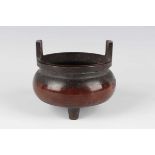 A Chinese brown patinated bronze tripod censer, mark of Qianlong but later, of low-bellied