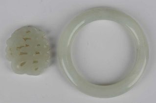 A Chinese pale celadon jade bangle, diameter 8.4cm, inner diameter 6.1cm, together with a pale