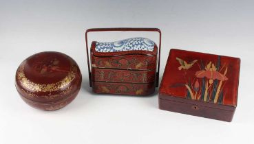 A Chinese red lacquer three-tier box with overhead handle, late 19th/early 20th century, decorated
