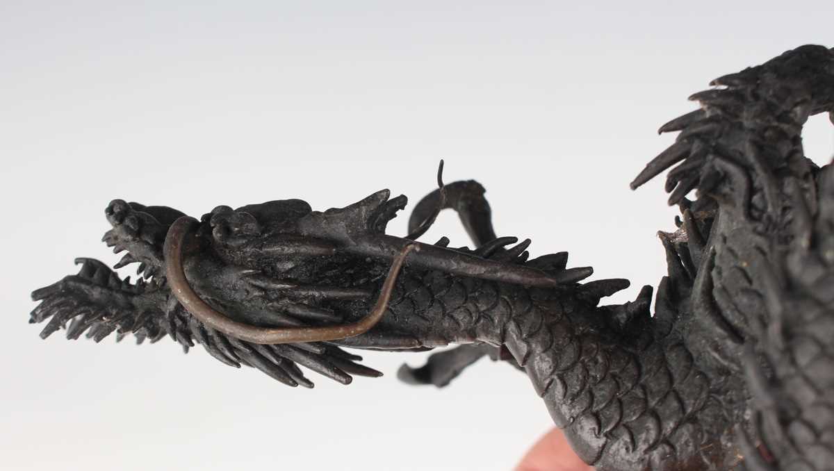 A Japanese cast bronze figure of a dragon, 20th century, modelled in a coiled pose holding a - Image 8 of 9