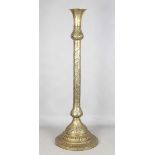 An Islamic brass floor lamp, circa 1900, the flared surmount and cylindrical column decorated with